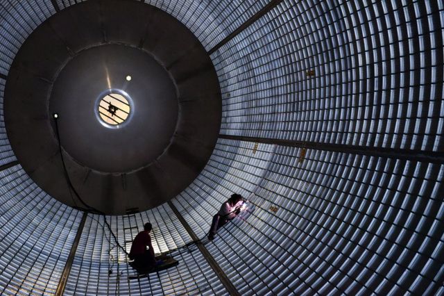 Workers inside the SLS hydrogen tank perform wall maintenance