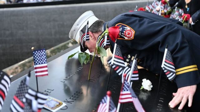 Charlie Wells, the retired head of nursing staff, kisses the names of relatives killed in the World Trade Center attack