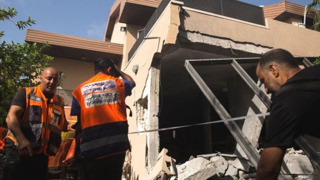 हमास के रॉकेट हमले में नष्ट हुए घर में इसराइली बचाव दल