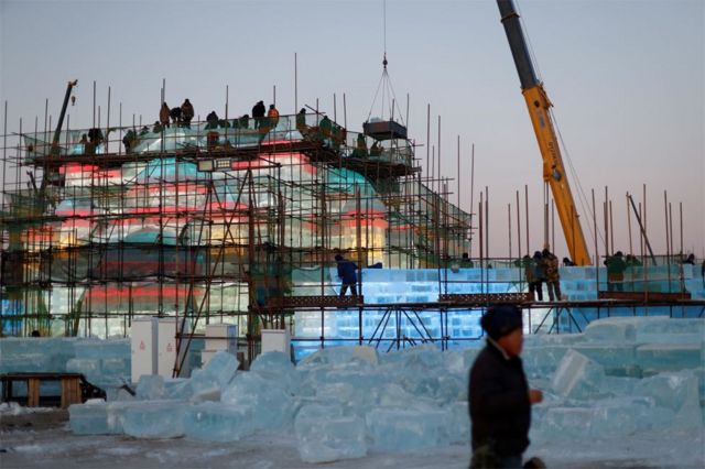 عمال السقالات يقومون ببناء هيكل جليدي في موقع مهرجان هاربين الدولي للجليد والثلج