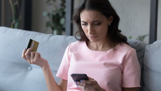 Una mujer revisa en su móvil las transacciones sospechosas de su tarjeta de crédito