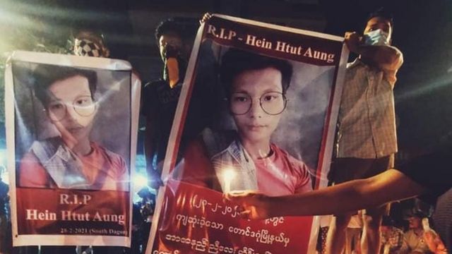 People show banners of Hein Htut Aung's photo after he was killed