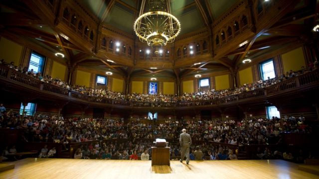 Michael Sandel dando una clase a cientos de alumnos en un teatro de Harvard.