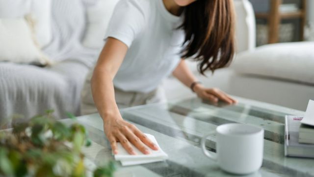 Mulher limpando uma mesa