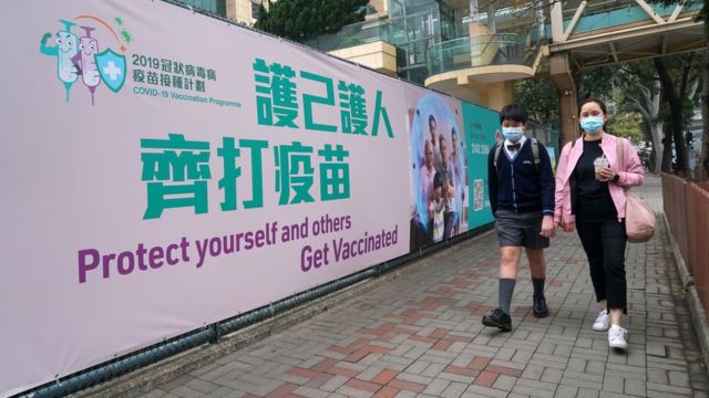 Passers-by walked past a large promotional banner outside the community vaccination center of the Hong Kong Central Library in Causeway Bay (Photo 5/3/2021 of China News Service)