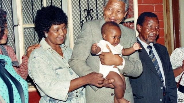 Nelson Mandela and his then-wife Winnie play with their grandchild Bambata at their Soweto home 21 February 1990