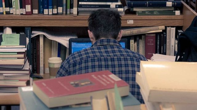 Stock photo of student surrounded by books