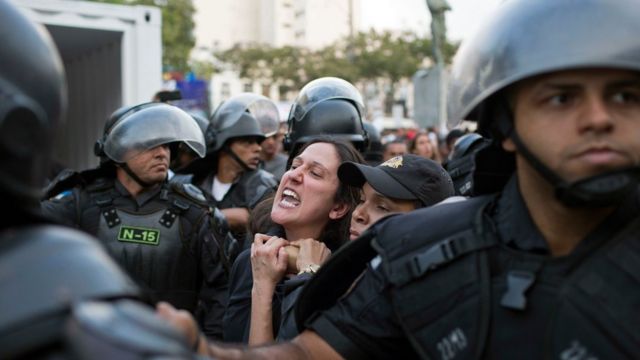 Manifestante é imobilizada durante protesto na passagem da tocha olímpica em Niteroi na terça-feira