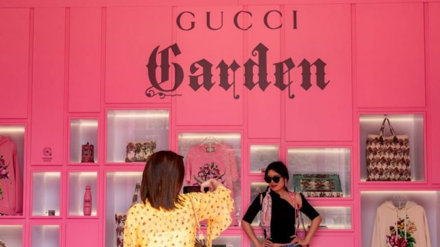 Dos mujeres recorren la colección de Gucci Aria en la exposición por el centenario de Shanghái.