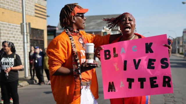 Dos mujeres sostienen un cartel que dice "Las vidas de los negros son importantes"