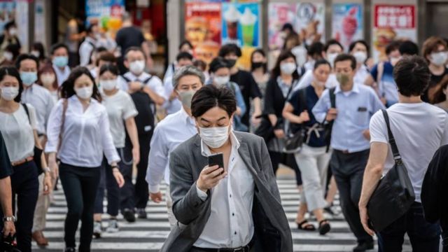 Japanese people walk down a street in Tokyo