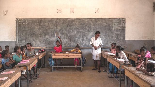 Olukọ kan duro, o n kọ awọn akẹkọọ