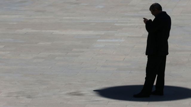 Bakıda telefonuna baxan kişi