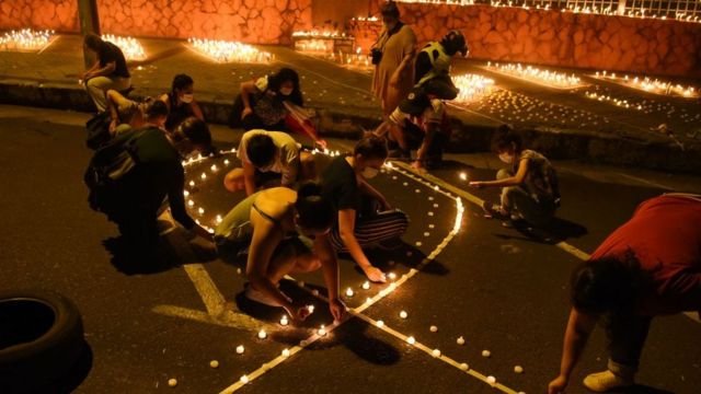 Familiares de las víctimas de covid encienden velas frente al Ministerio de Salud en Asunción, Paraguay