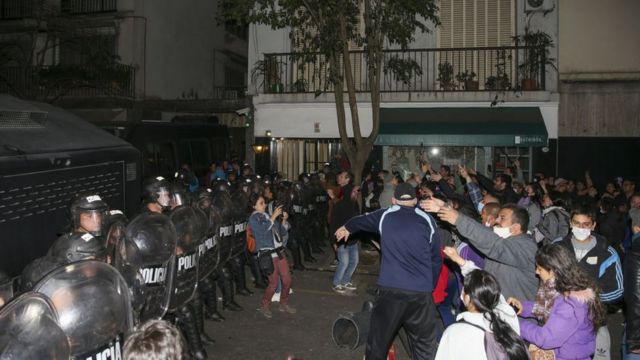 Manifestantes e policiais de choque do lado de fora da casa da vice-presidente Cristina Kirchner