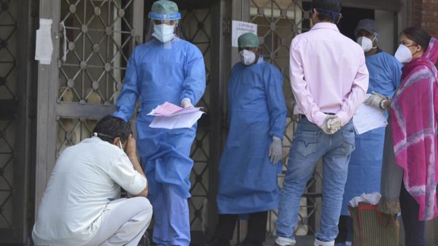 A medical worker brings out a patient report at a Delhi hospital
