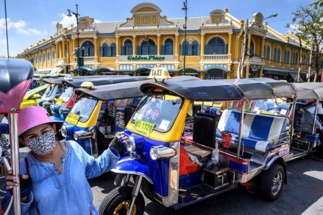 A tuk-tuk driver, wearing a facemask amid concerns about the spread of the COVID-19 novel coronavirus, waits for tourists in front of the Grand Palace in Bangkok on March 6, 2020