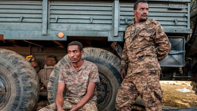 Two Ethiopian soldiers next to an army truck