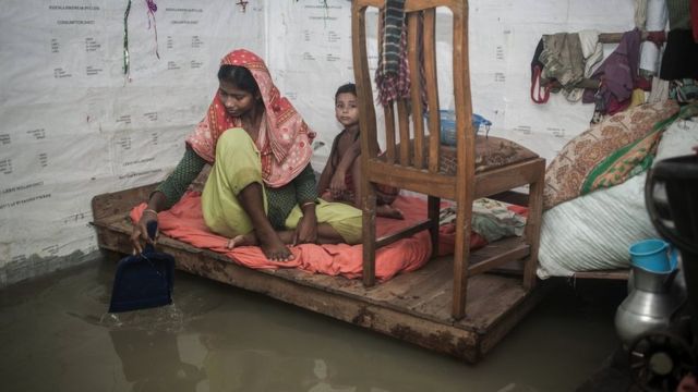 Mujer y niña en una habitación inundada en Chittagong
