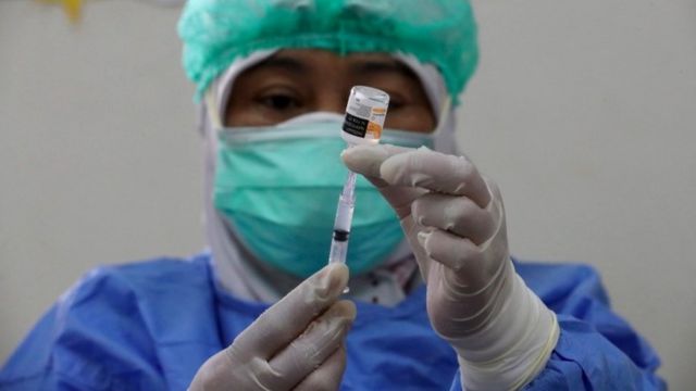 عامل طبي إندونيسي يجهز جرعة من لقاح سينوفاك