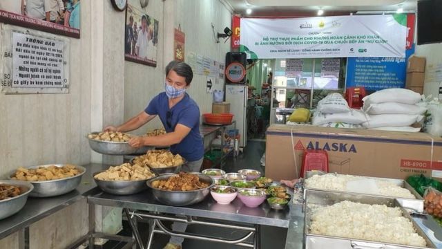 Hỗ trợ viên Nguyễn Tập chuẩn bị các suất ăn cho người dân ở Quán cơm Nụ cười