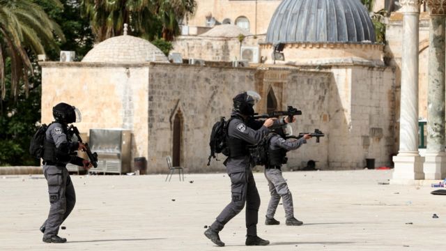 Israeli police officer aims a weapon during clashes with Palestinians around the al-Aqsa mosque in occupied East Jerusalem (10 May 2021)