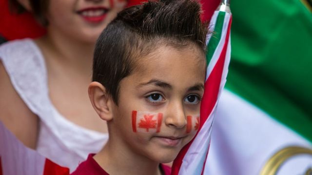 Un niño con la bandera de Canadá pintada en los canchetes durante el desfile del Día de Canadá en Montreal, Quebec.
