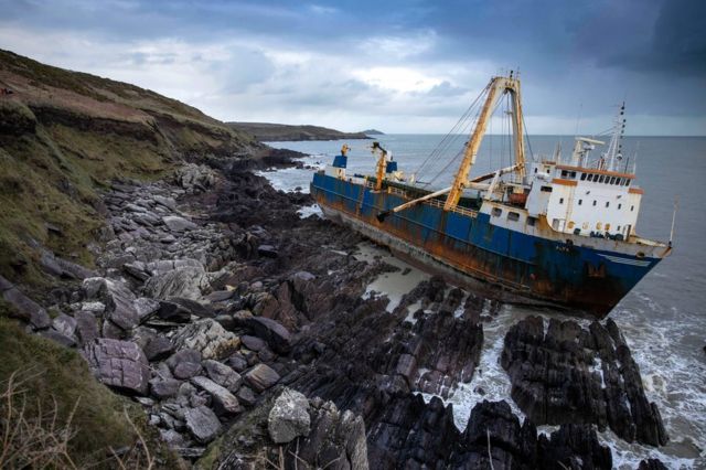 Imagem do barco fantasma Alta, preso nas pedras da costa da Irlanda