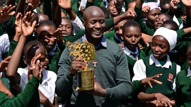 Peter Tabichi akiwa na wanafunzi na tuzo aliyotuzwa