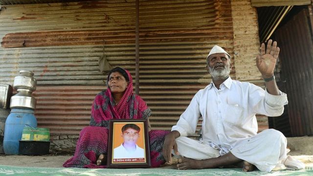 Una pareja dalit con la foto de su hijo muerto