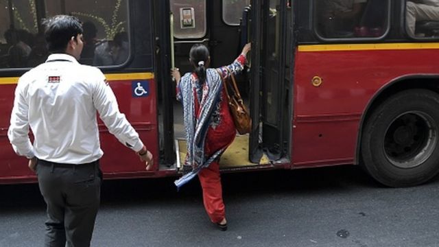 An Indian woman boards a bus