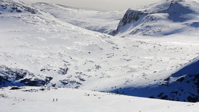 Esquiadores de montaña en la meseta de Cairngorm en plenas condiciones invernales, Escocia, Reino Unido.