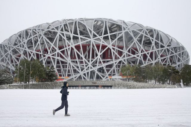 Despite the cold weather, a man was jogging near the bird's nest.