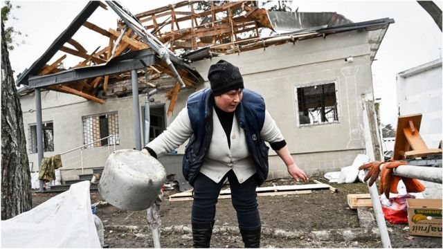 A woman in a destroyed house in Ukraine