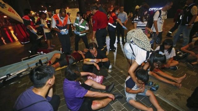 Injured people are helped by emergency rescue workers outside a station after an explosion on a passenger train in Taipei, Taiwan, Thursday, July 7, 2016