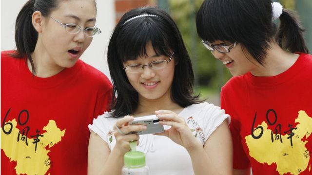 Chinese students attending the Nanyang Girls' High School look at a digital camera