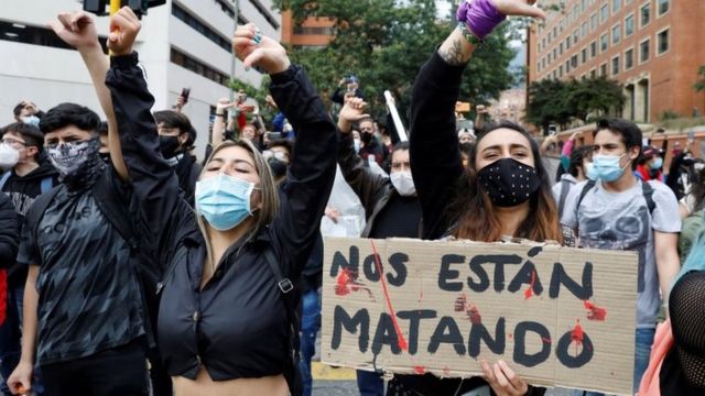 Manifestantes en Bogotá con un letrero que dice "Nos están matando".