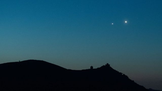 يرتفع كوكبا المشتري والزهرة قبل شروق الشمس خلف قلعة روكا كالاشيو، إيطاليا، في 30 أبريل/نيسان 2022
