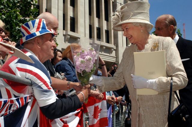 Queen Elizabeth II akipokea maua kutoka kwa Terry Hutt nje ya kanisa la St Paul's Cathedral, London, baada ya ibada ya kutoa shukrani baada yake kutimiza miaka 80