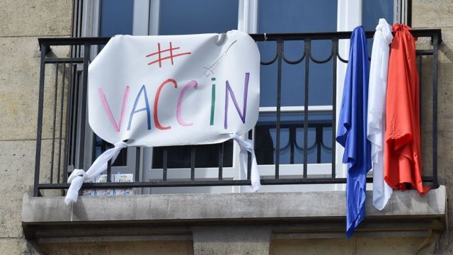 Баннер со словом "вакцина", вывешенный на балконе в Париже