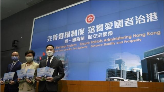 From Left to Right Mr. Eric Tsang Secretary for Constitutional and Mainland Affairs , Ms Carrie Lam Hong Kong Chief Executive , Mr Roy Tang Permanent Secretary for Constitutional and Mainland Affairs, holds a booklet while posing for a photo before a press conference in Hong Kong, Tuesday, March 30, 2020.