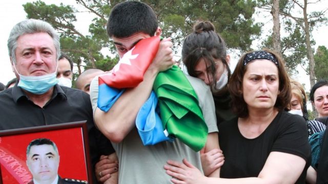 Mourners gather at the grave of an Azeri killed in border clashes with Armenia