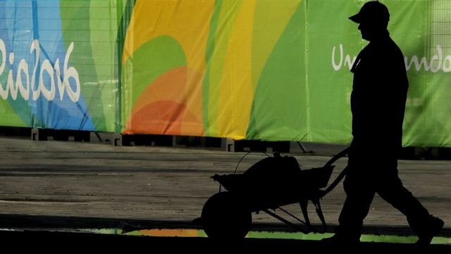 Trabajador pasa frente a la villa olímpica en Río