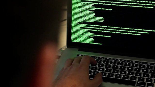 Man looking at code on laptop