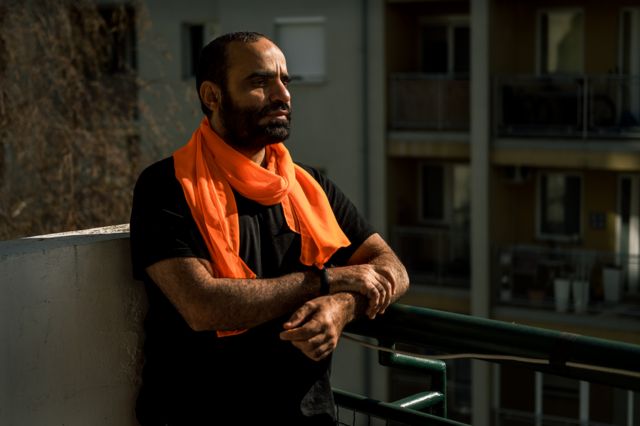 منصور الضيفي يجلس في شرفة شقته في بلغراد. يقول، "غوانتانامو يلاحقك أينما ذهبت" (الصورة: جول غنتر، بي بي سي)