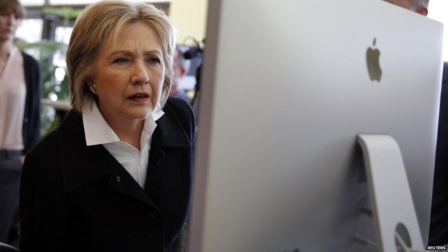Hillary Clinton looks at a computer screen during a campaign stop in Iowa