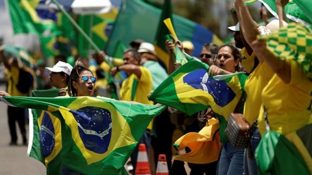 Manifestantes ondeando la bandera brasileña