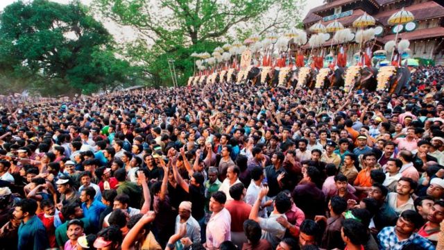 Thousands gathers before a temple in Kerala. Ceremonial elephants can be seen in the background.