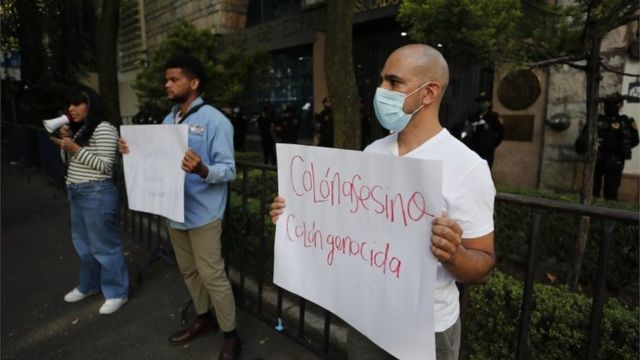 2021年10月12日，墨西哥城抗议者在西班牙大使馆外举着“种族灭绝”标语。(photo:BBC)