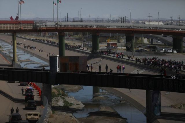 Migrantes, en su mayoría de origen venezolano, intentan cruzar por la fuerza a Estados Unidos en el Puente Internacional Paso del Norte en Ciudad Juárez, estado de Chihuahua, México, el 12 de marzo de 2023.